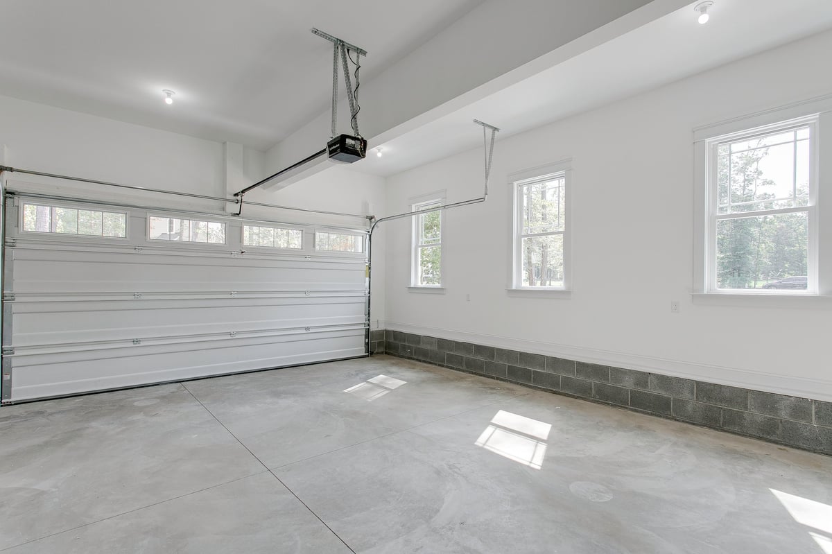 Clean, bright garage with dual overhead doors and natural light — freshly cleared out